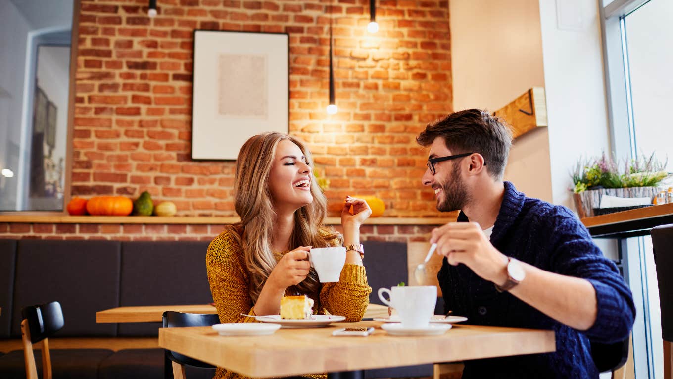 Couple of young people drinking coffee and eating cake in a stylish modern cafeteria