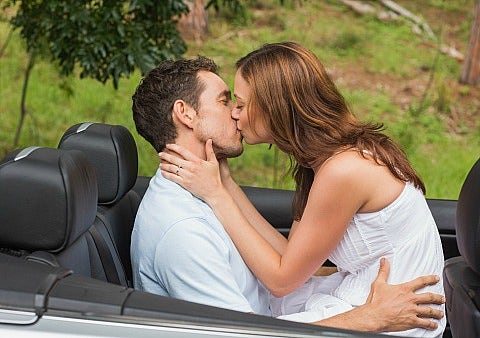 couple kissing in convertible 