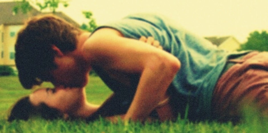 couple kissing in grass