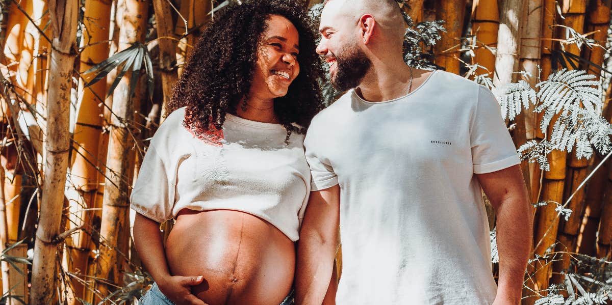 Pregnant woman holding hands with partner