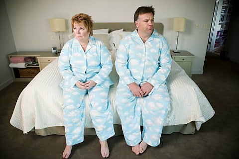 couple sitting on bed in matching pajamas
