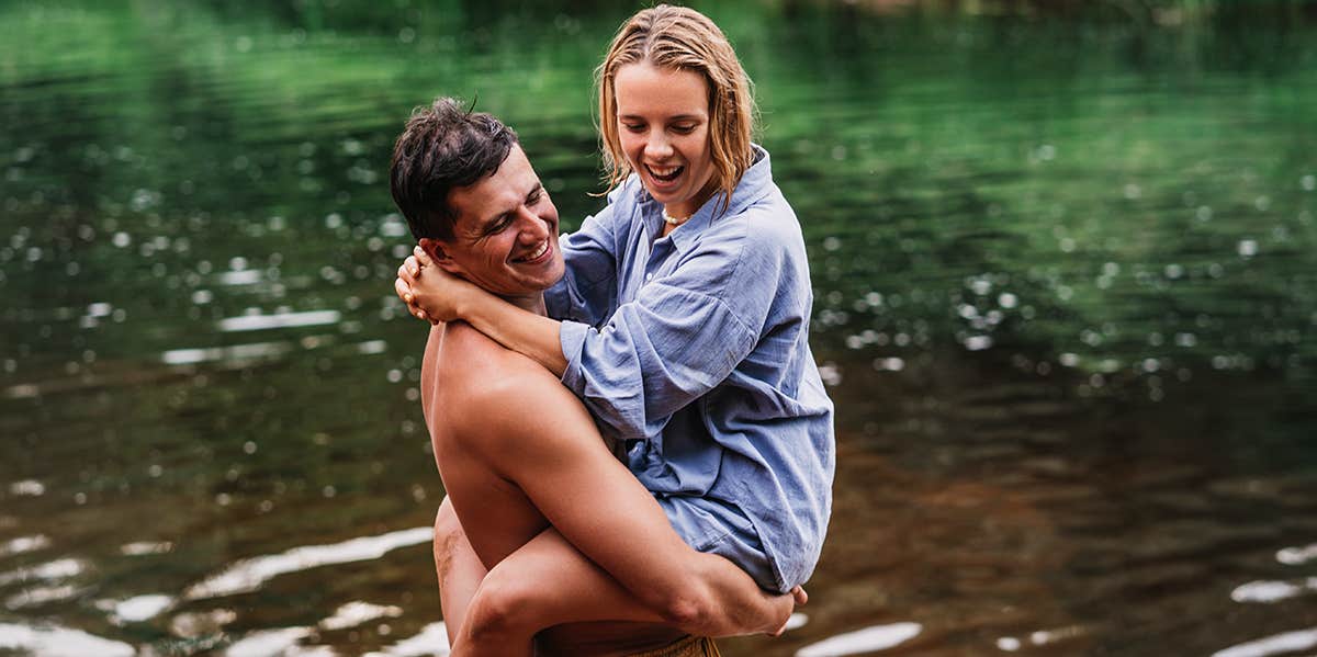 man carrying girl swimming in river