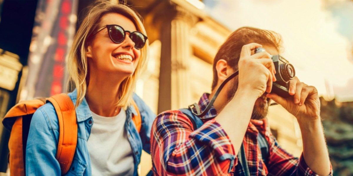 man and woman taking pictures outside