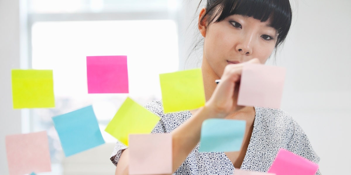 creative blocks woman writing on post its