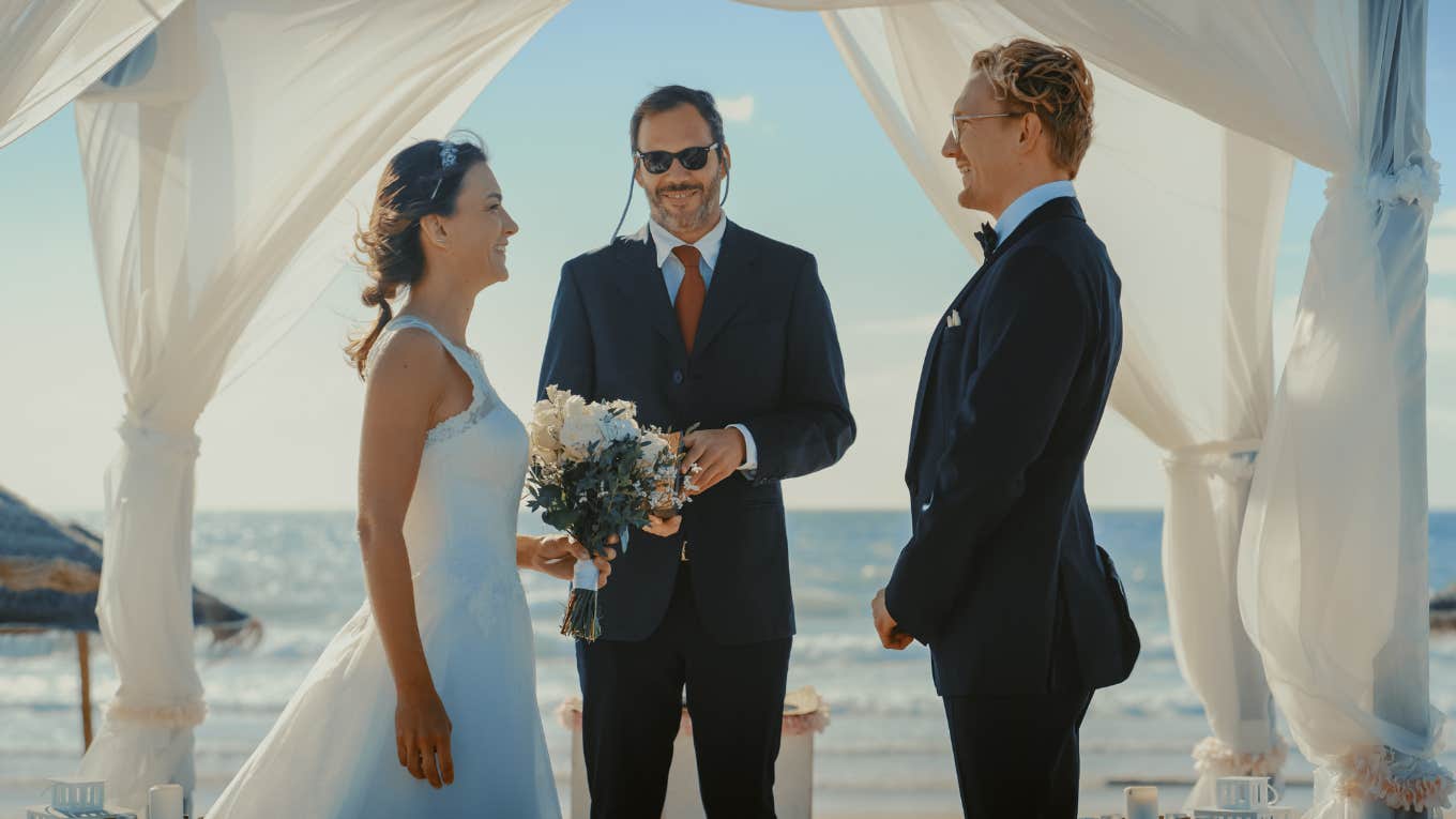 Bride and groom stand at the wedding altar with an officiant