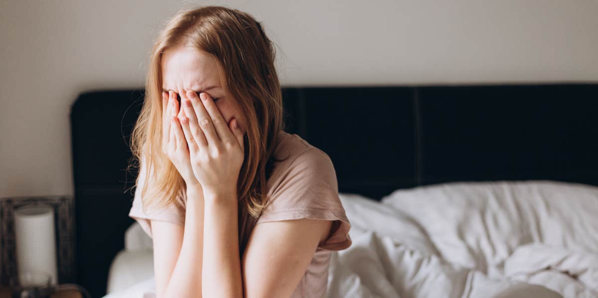 woman crying on bed