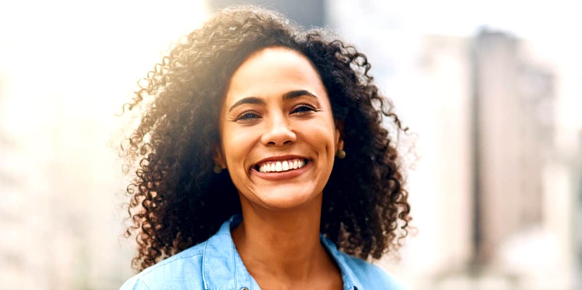 Cut negative cords Independent woman smiles at viewer