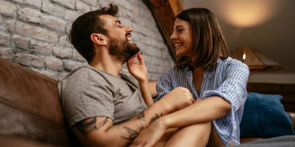 boyfriend and girlfriend smiling at each other on the couch