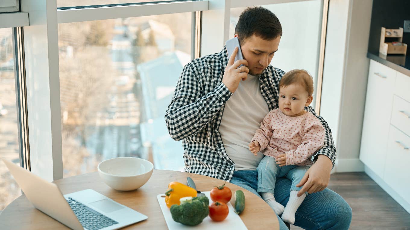 man on the phone holding a babe