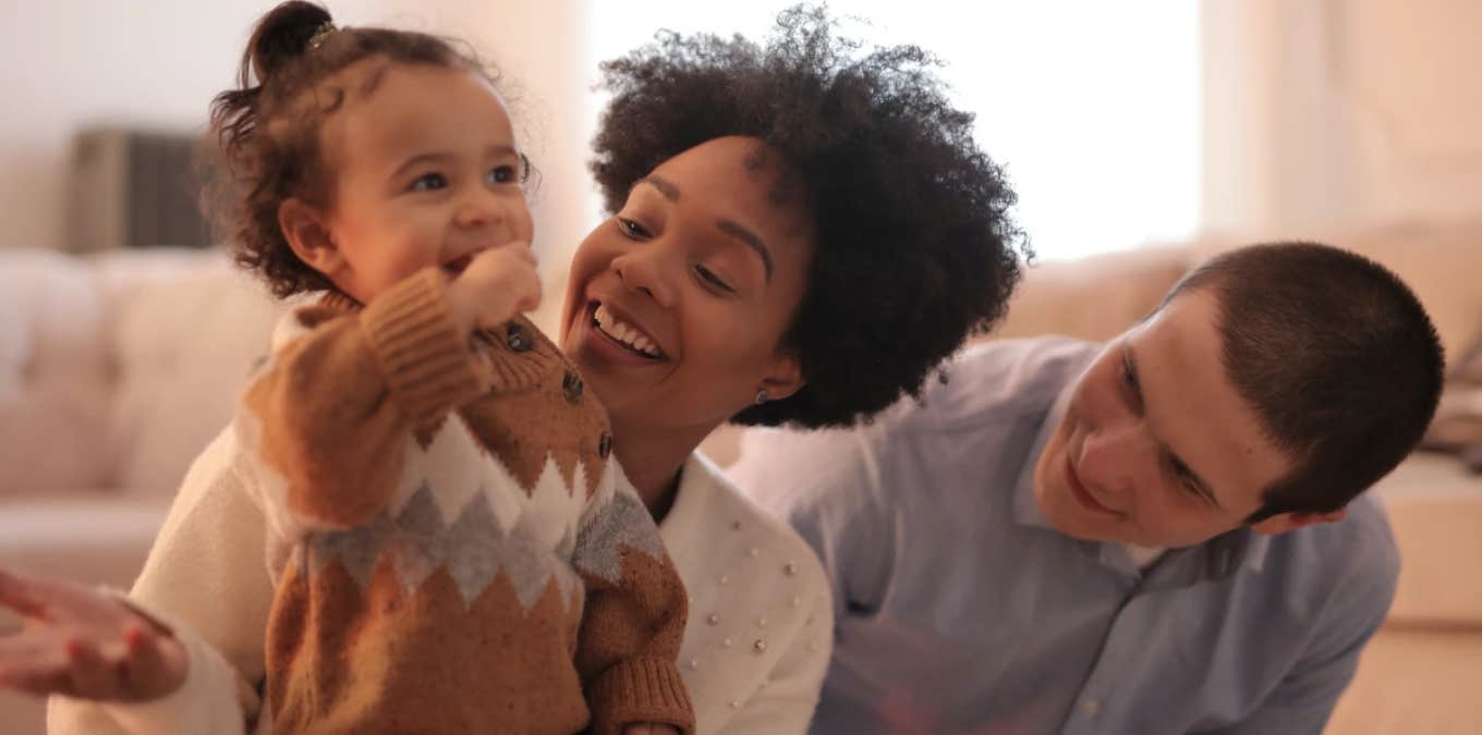 mom dad and baby smiling happy