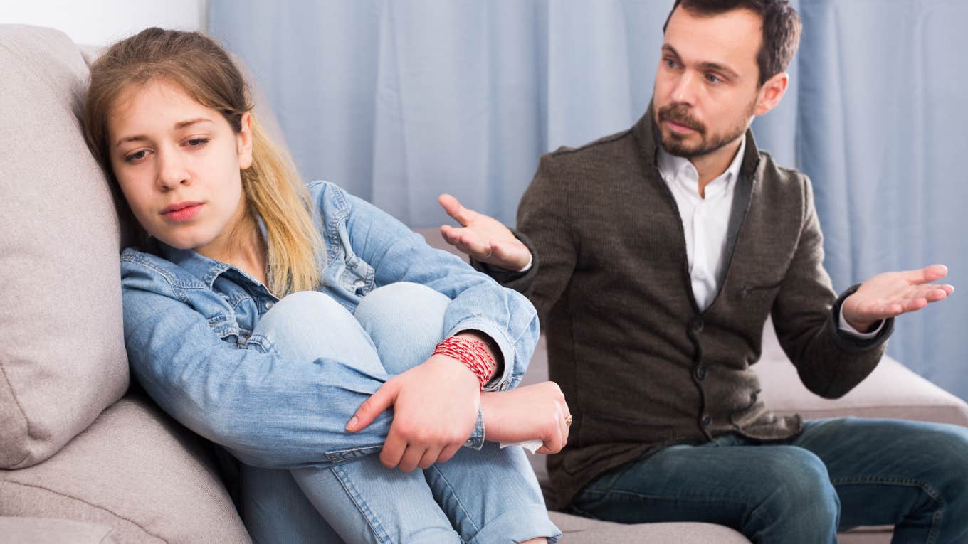 father and daughter sitting on couch arguing