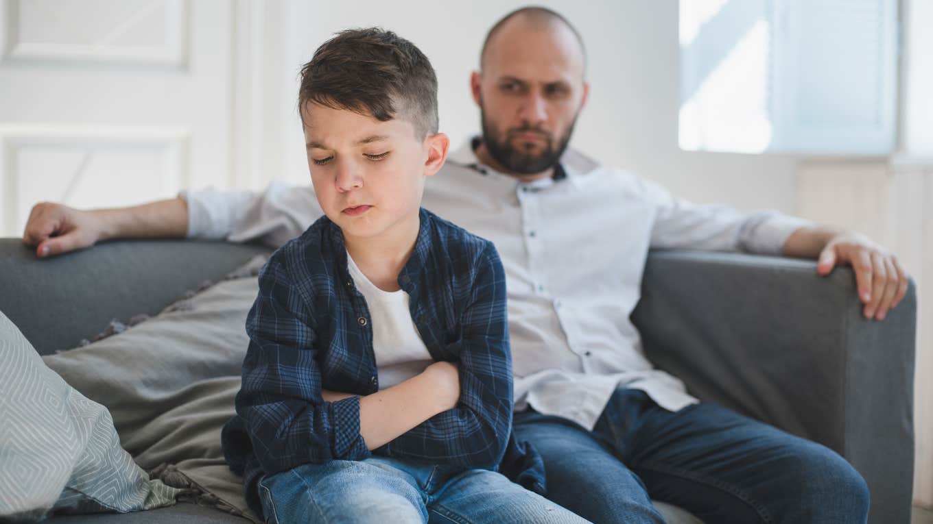 upset young boy in foreground and angry man in background