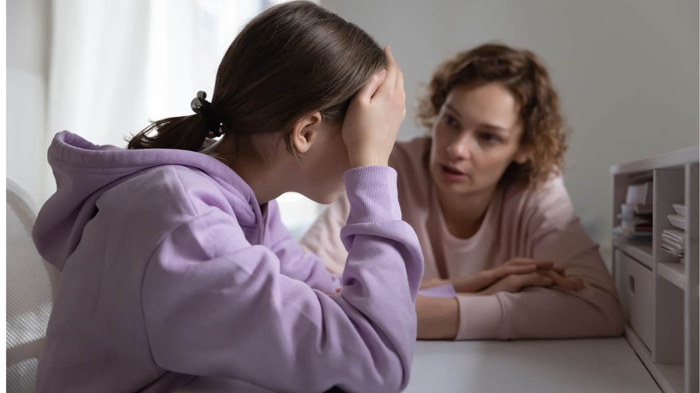 Teenage daughter looks upset while mom argues with her. 