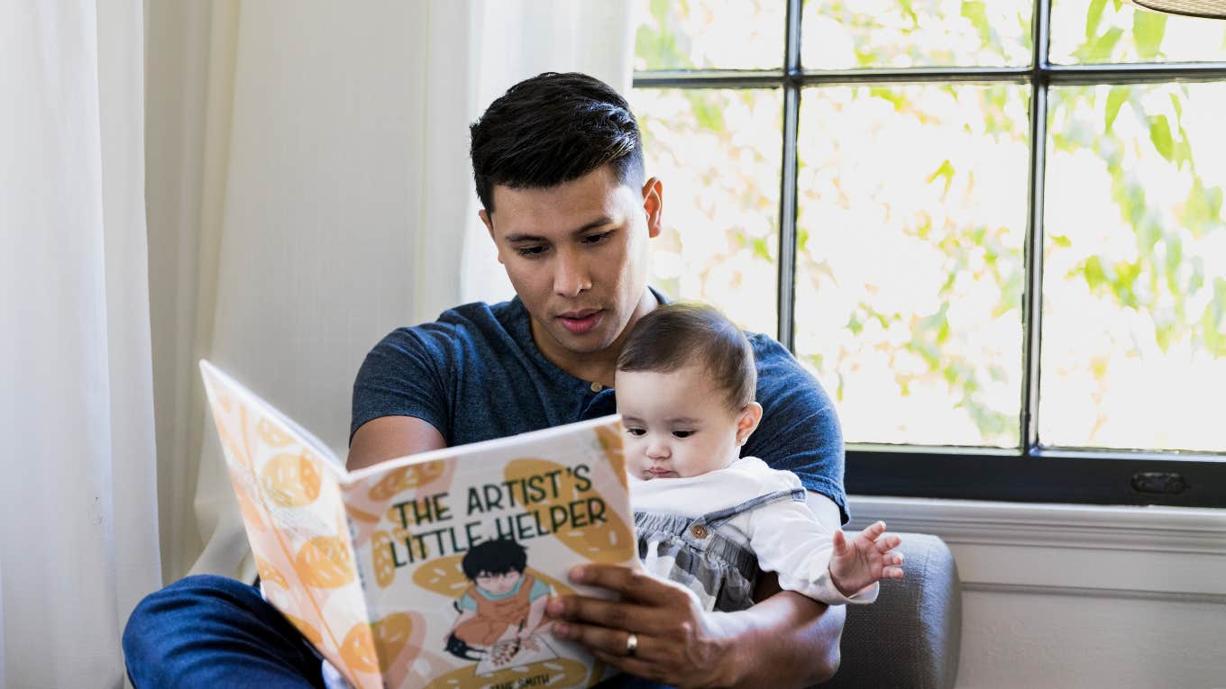 dad reading storybook to baby
