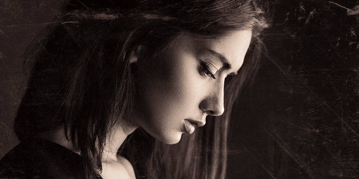 Experts Reveal The Most Damaging Lies We Learn From Narcissistic Parents sad woman in dark room