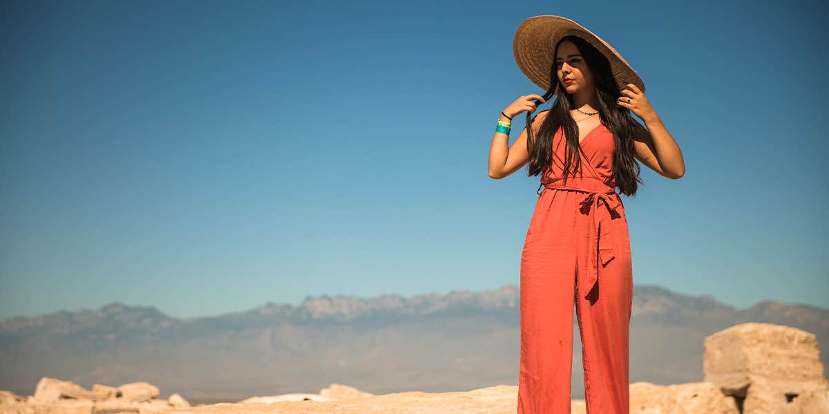 woman in orange jumpsuit and sun hat