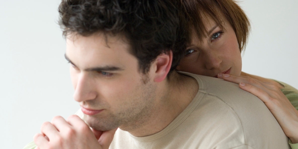 man thinking with woman hugging him from behind