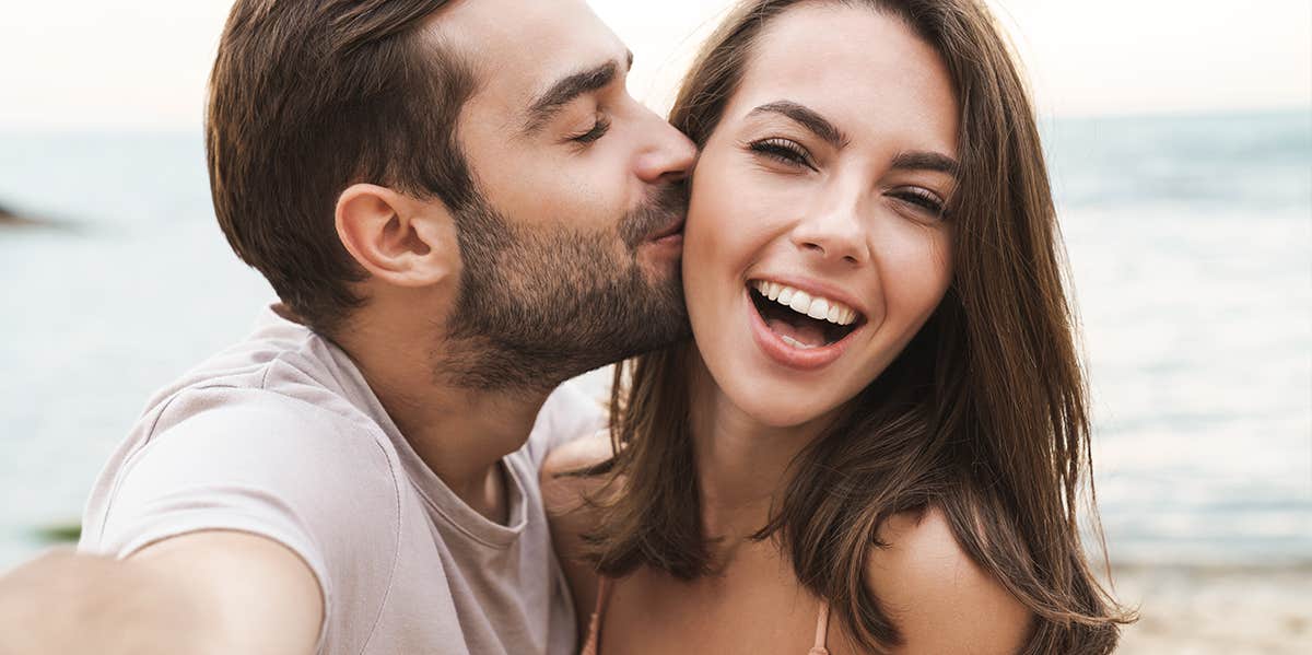 man kissing woman on cheek