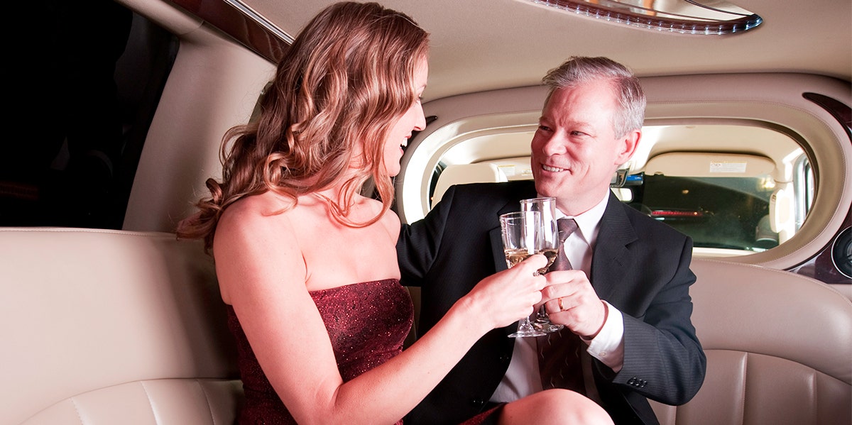 woman and man in limo together clinking champagne glasses