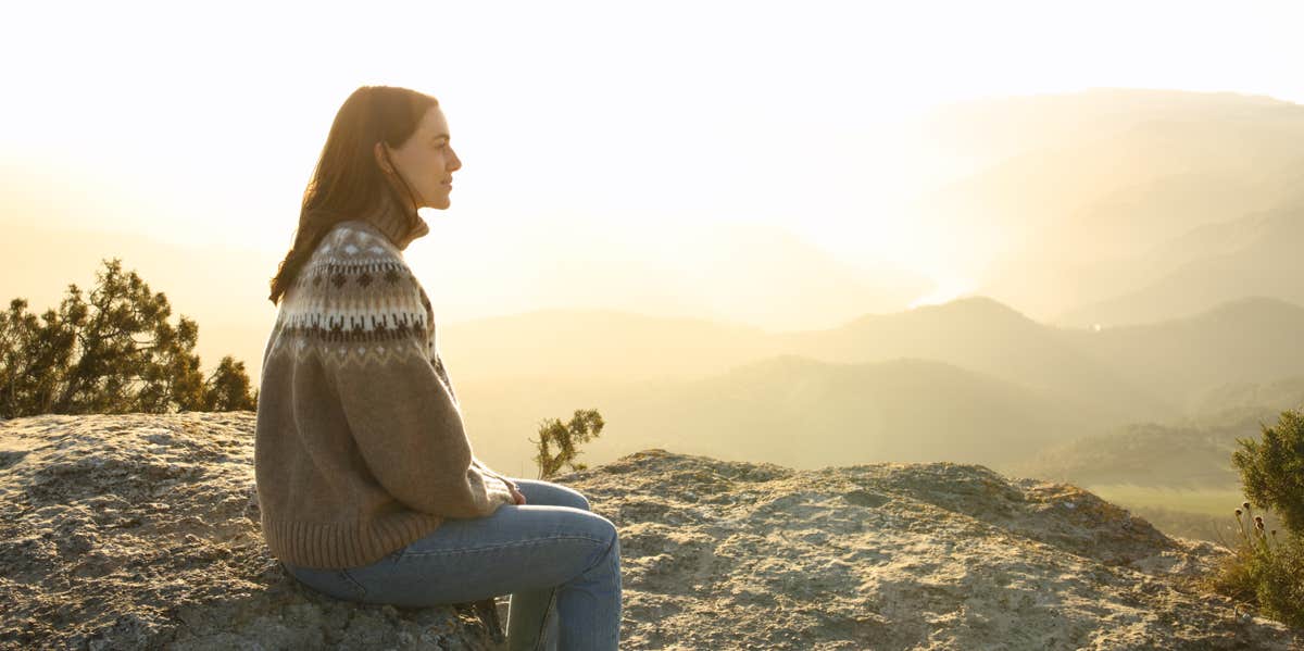 woman sitting on rock