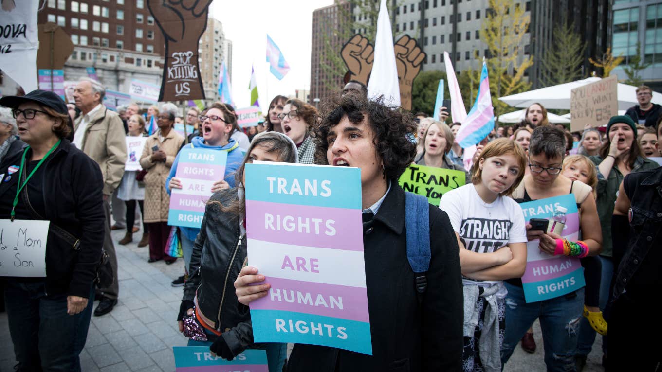 people gathered in trans protest against anti trans legislation, holding up signs