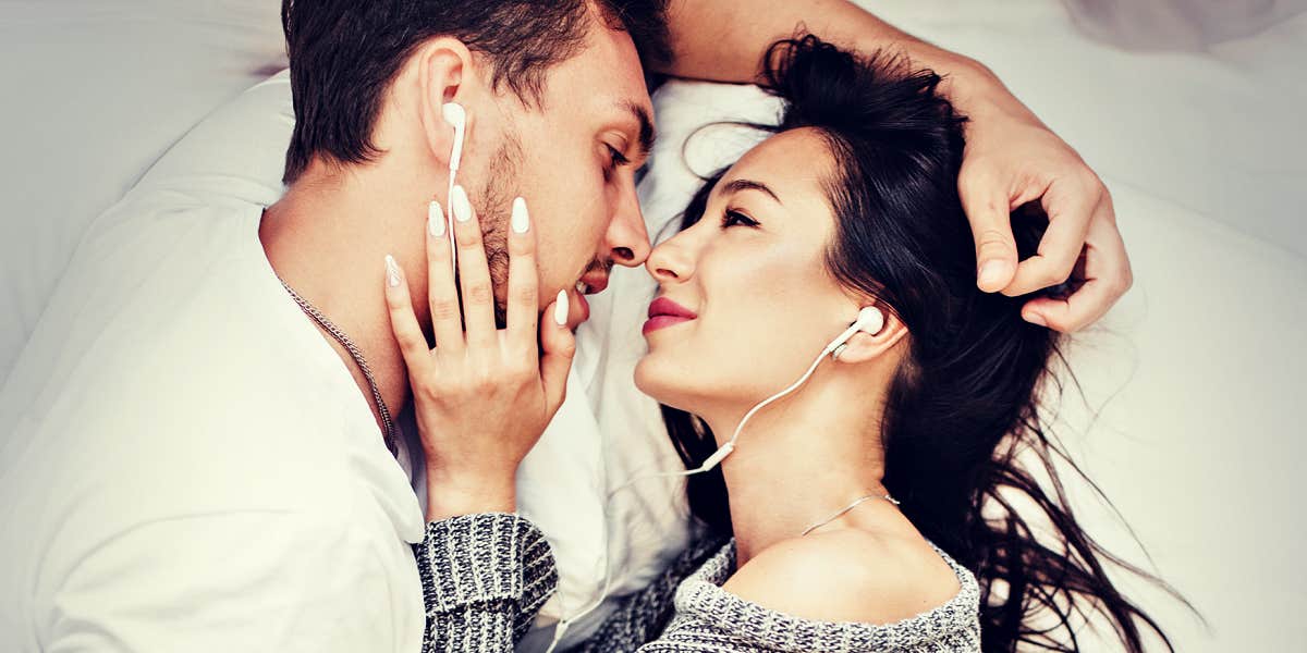 couple looking deeply connected, sharing earbuds 