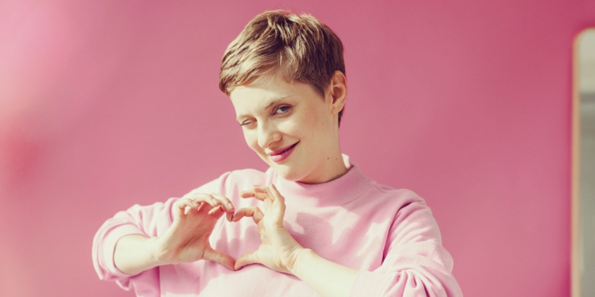 woman making a heart shape with her hands