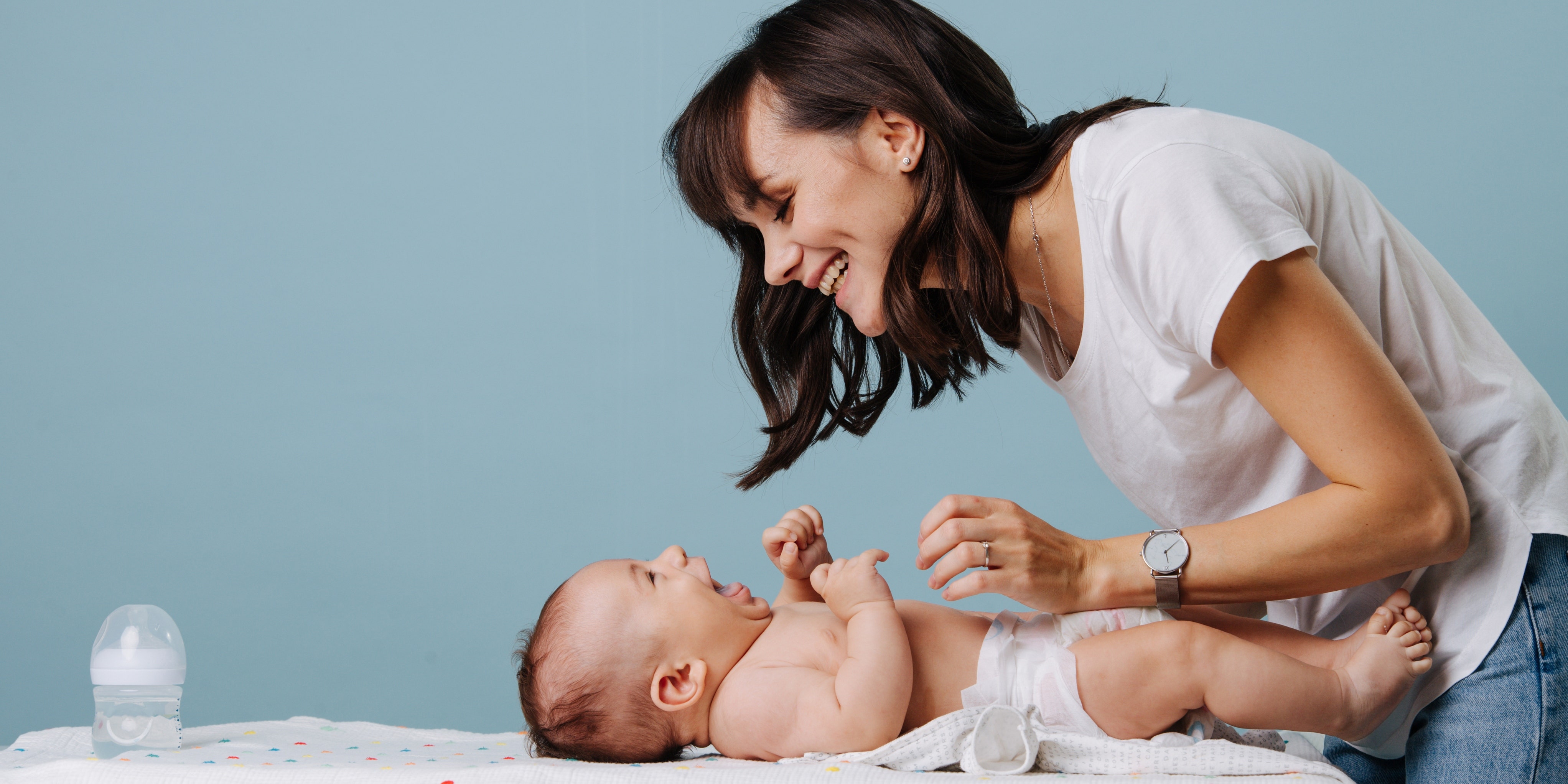 woman changing baby's diapers