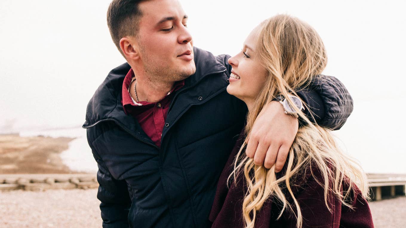 man with his arm around woman