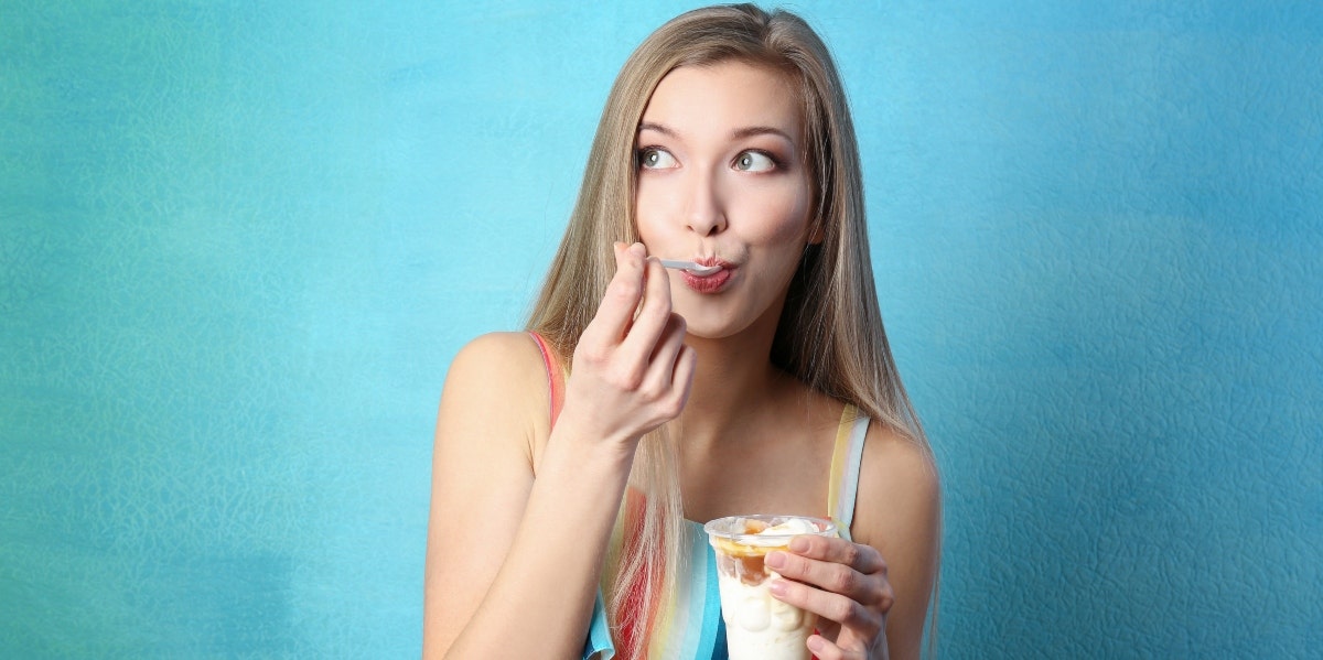 disordered eating woman eating ice cream in front of blue background