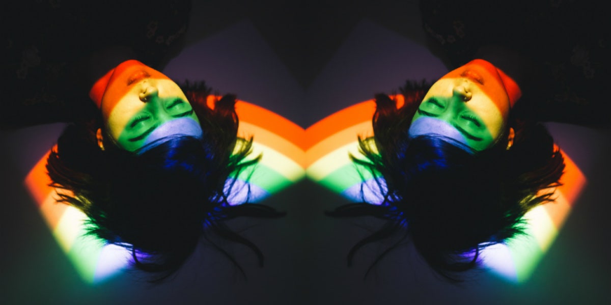 woman laying on floor with rainbow reflection on her face