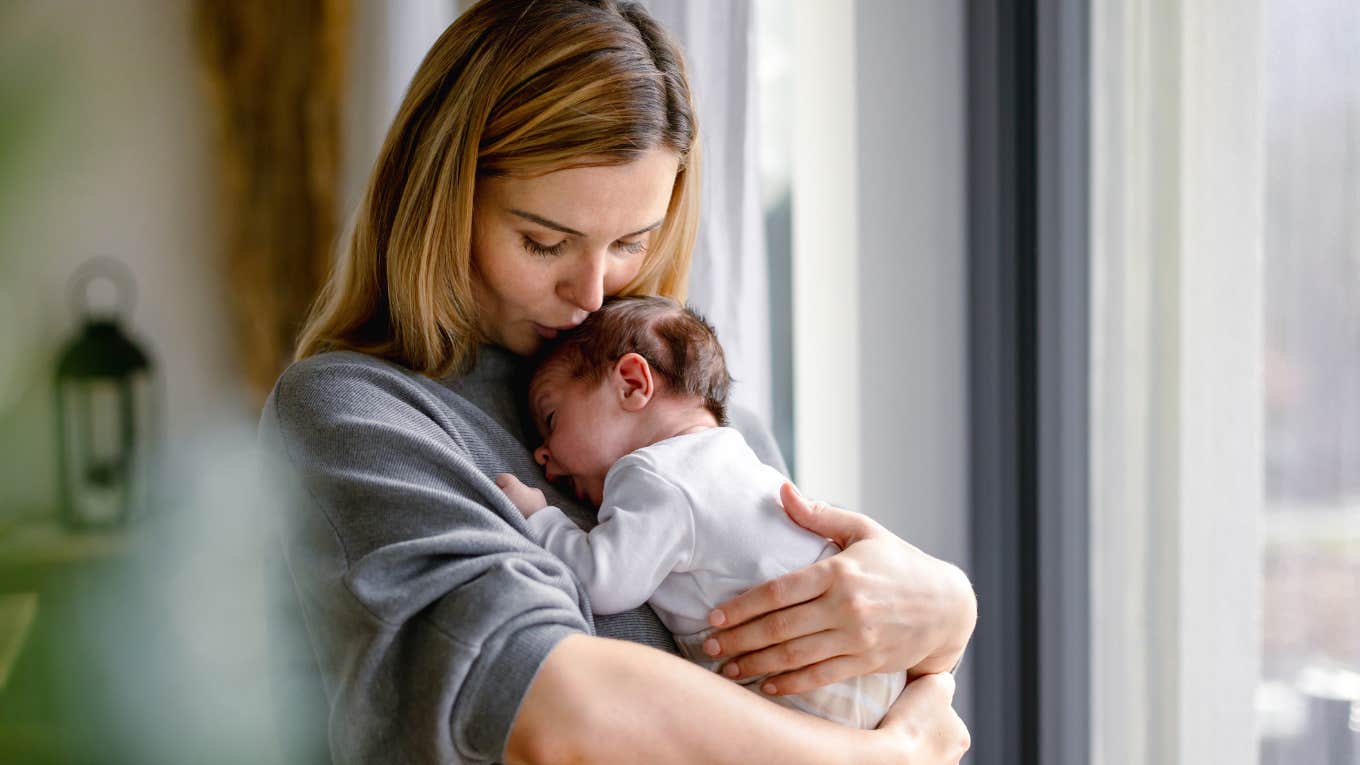 mother hugs her little baby at home