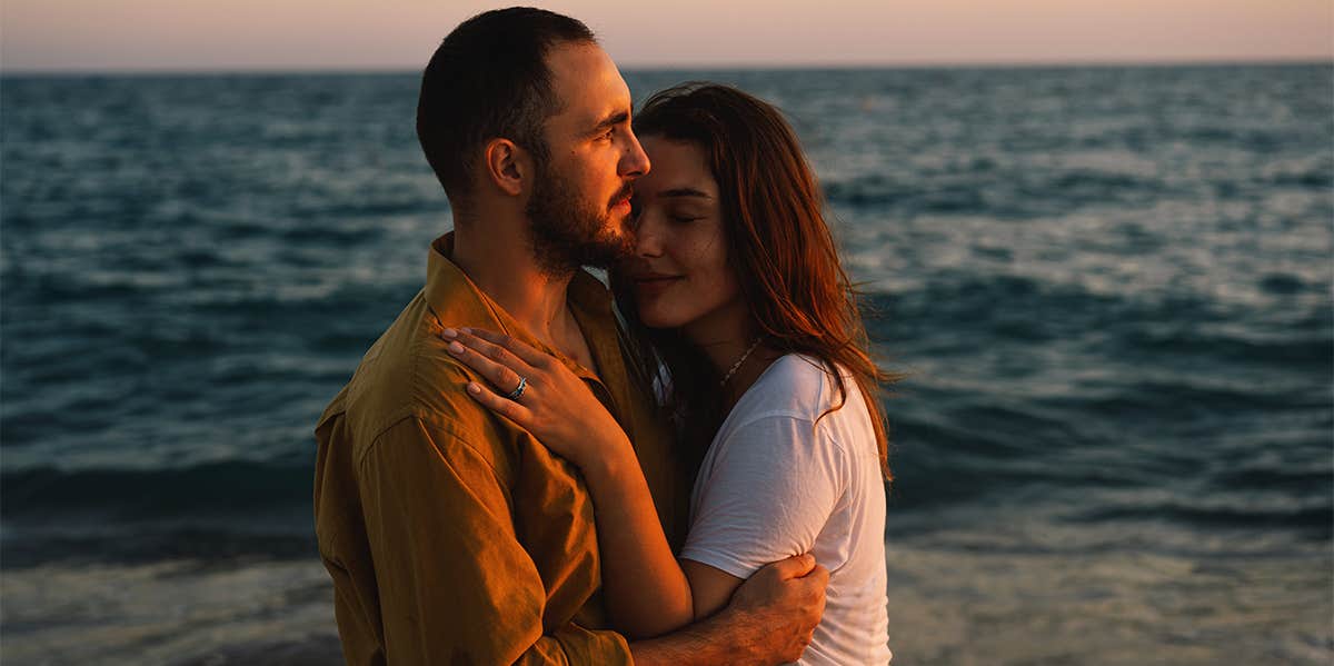 man and woman hugging on beach