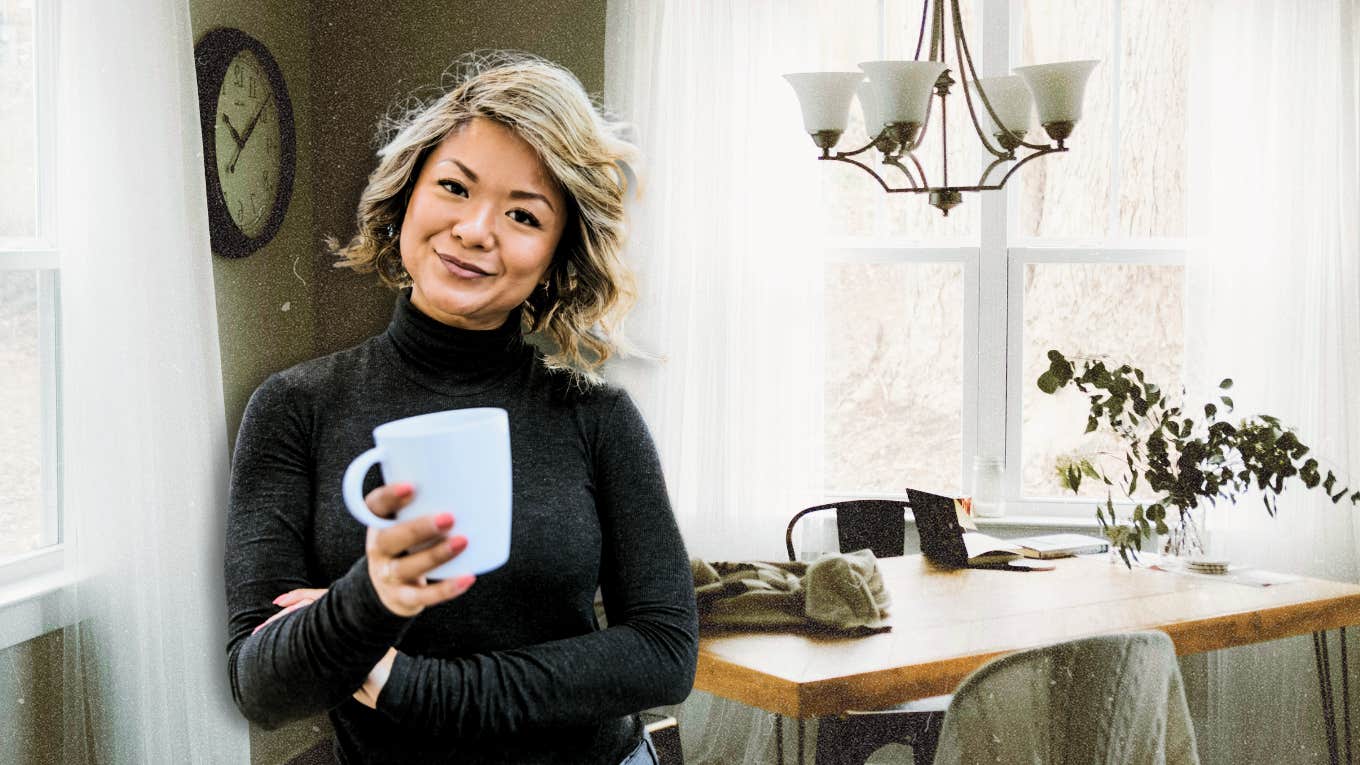 Confident woman holding a coffee cup in her kitchen 