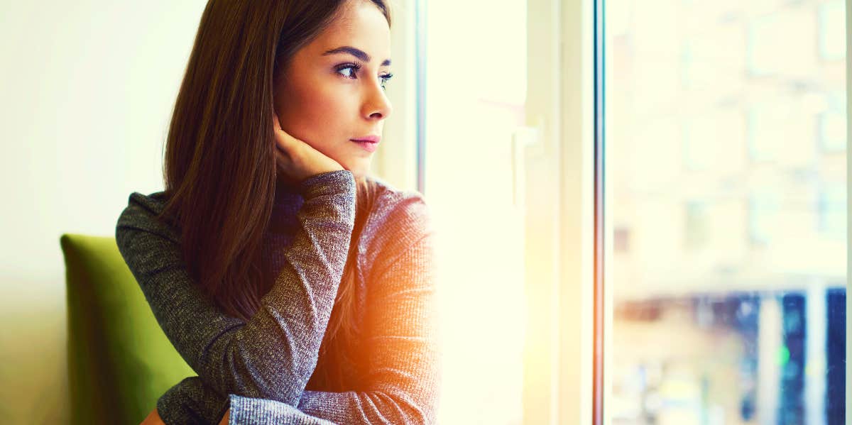 sad woman looking out of a window