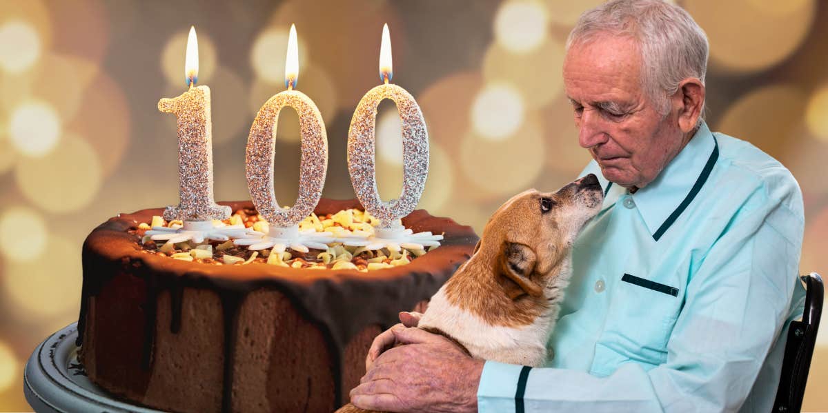 man holding a dog next to 100th birthday cake