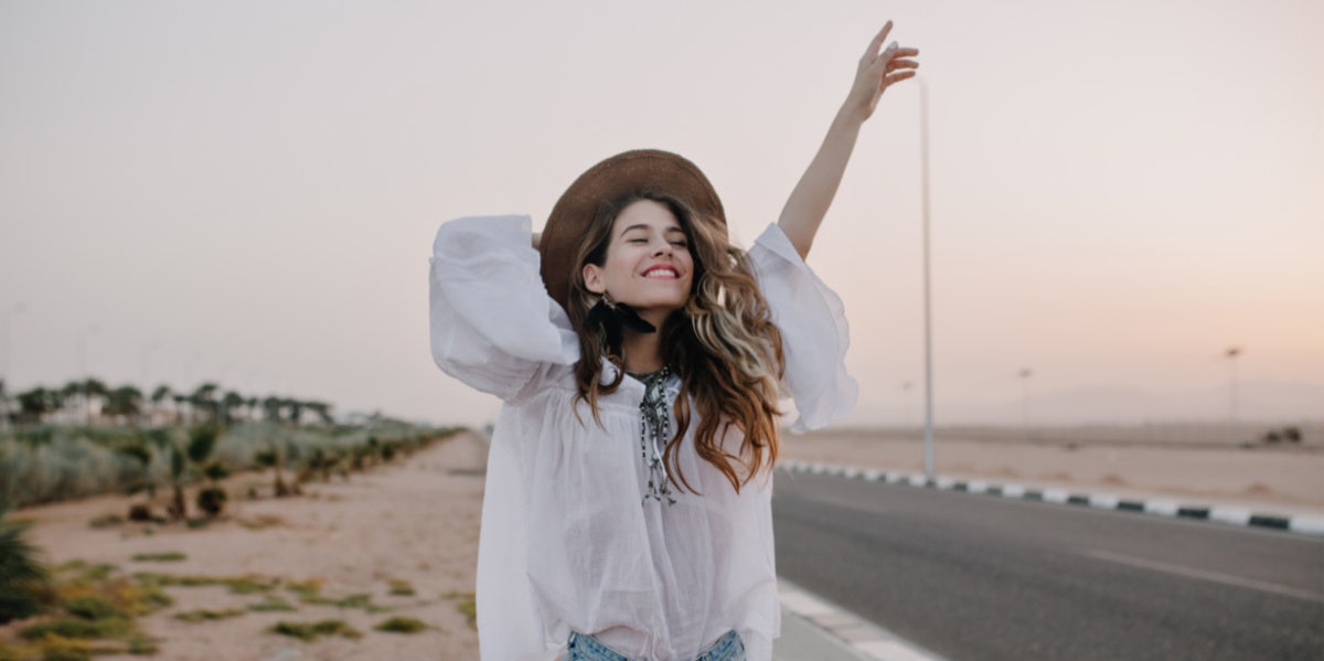 happy woman with arm up at beach