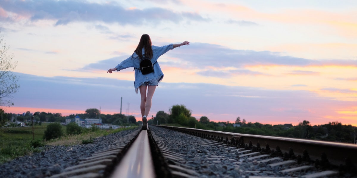 woman walking on train tracks