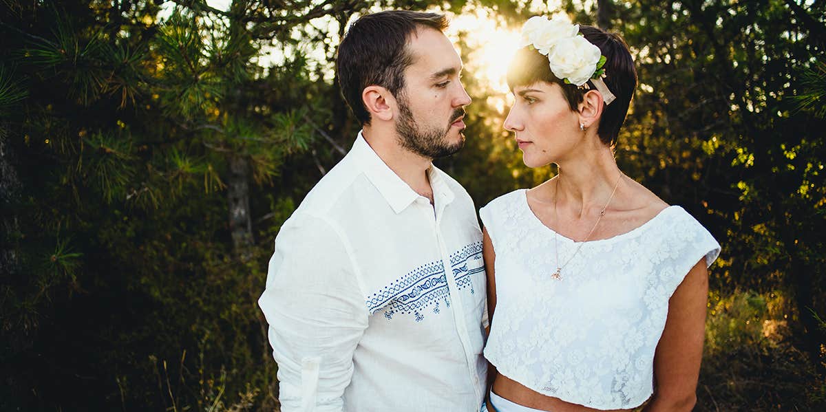 husband and wife on wedding day with sunset behind them