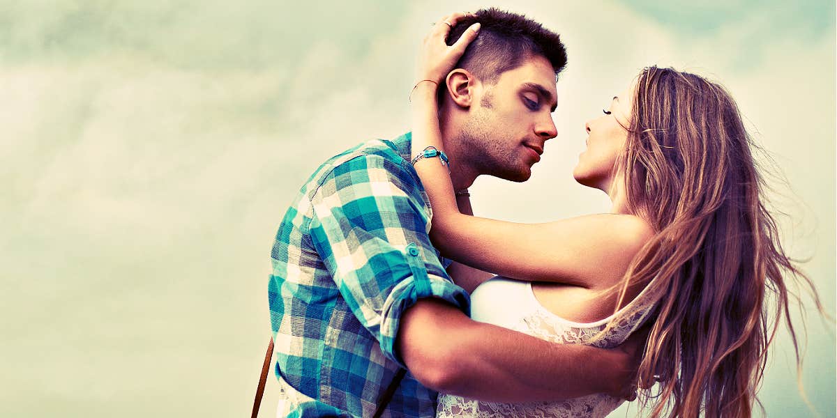 man trying to kiss a woman in front of a dramatic could sky