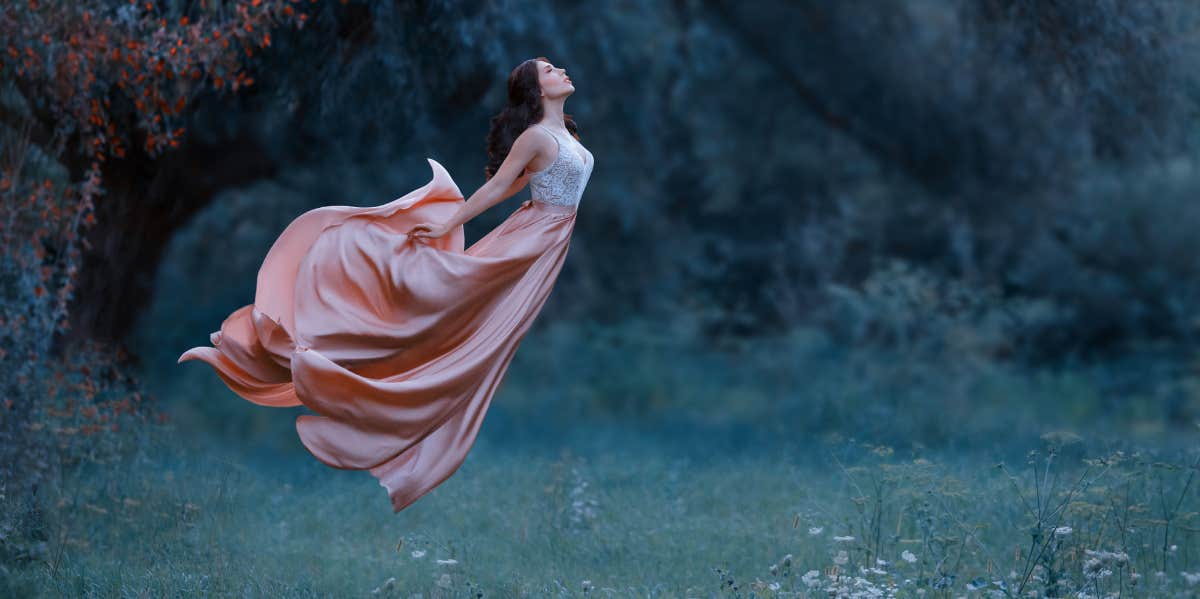 woman flying over a field