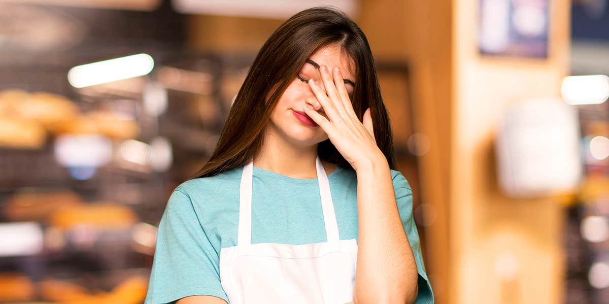 woman in apron looking flustered