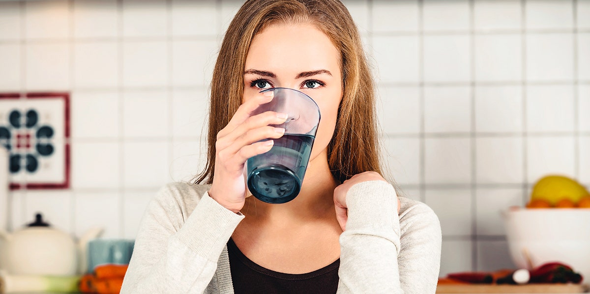 woman drinking water from glass