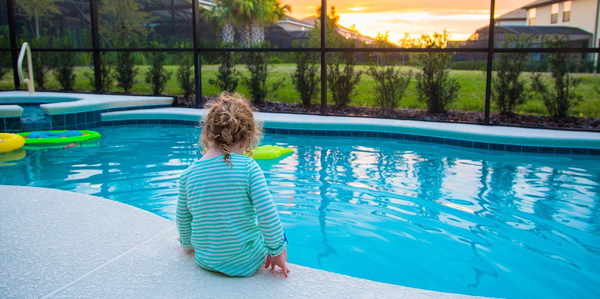 toddler sitting by swinning pool