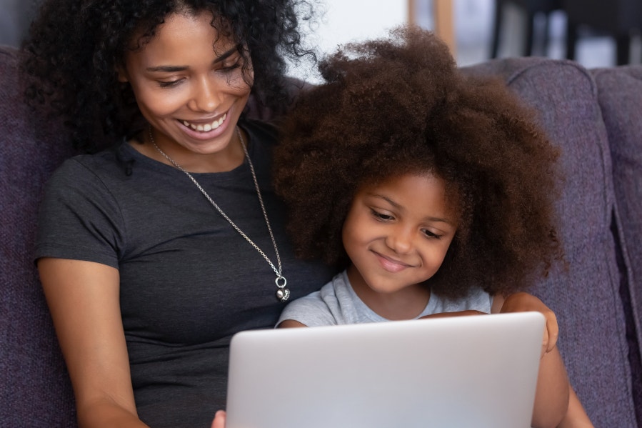 mom and young daughter looking at a laptop screen