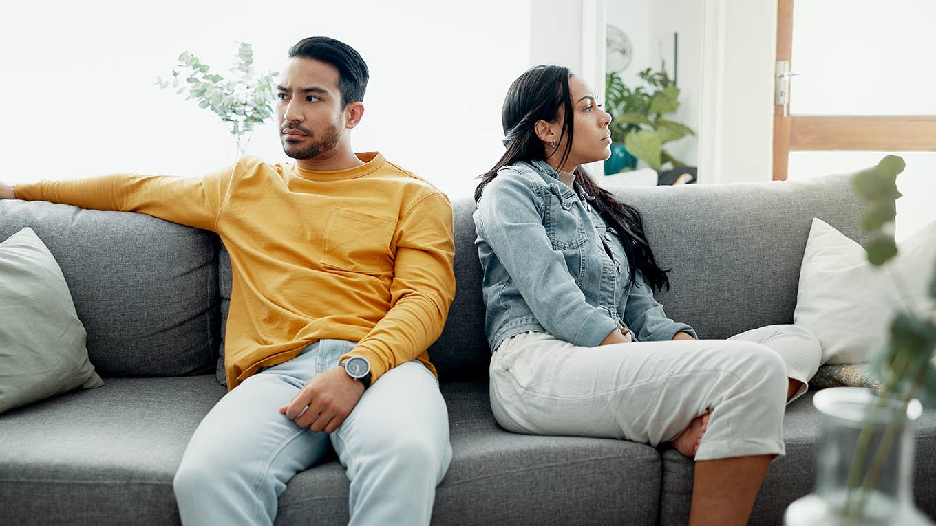 unhappy couple sitting on couch at home