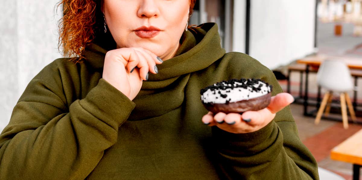plus sized woman holding doughnut