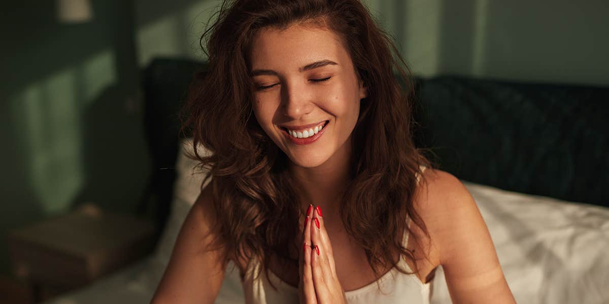 woman praying in bed