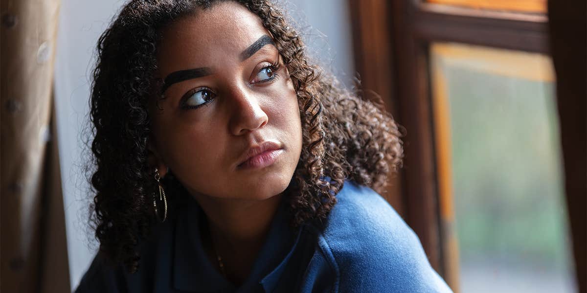 Why Do I Crave Abuse? 12 Signs You're An Emotional Masochist woman looking out the window