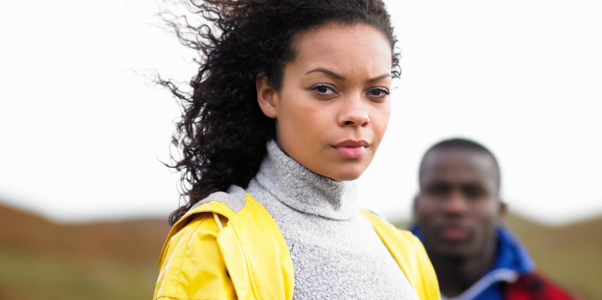 emotionally strong woman woman in a yellow jacket with man behind her
